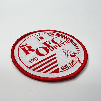 Las insignias rojas calientan el hierro de las técnicas del remiendo de la prensa que teje en el remiendo Eco amistoso